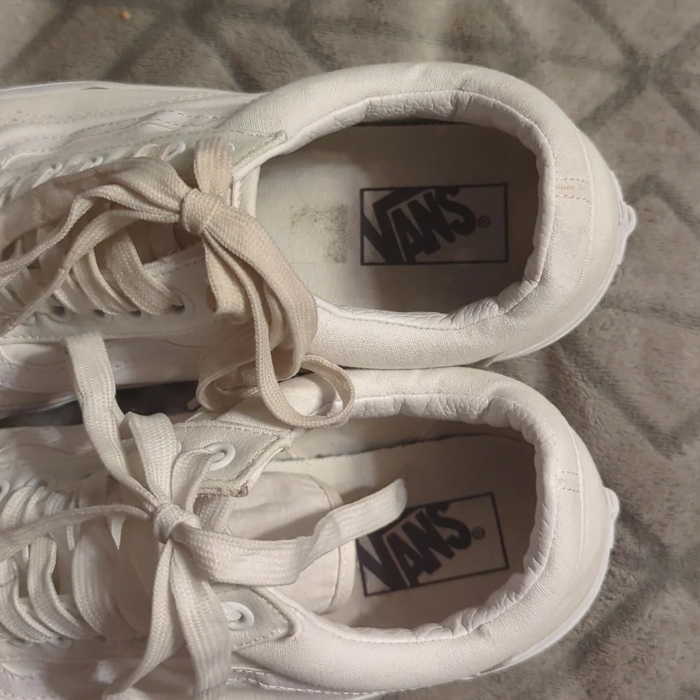 Vans Old Skool shoes in the True White or Monochrome‎ White colorway.